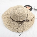 Beige woven straw sun hat with wavy brim and brown bow tie on white fabric - One Size / Hollow Flower with Cord - Beige