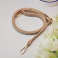 Detalle de correa de bolso ajustable beige motivo litchi con mosquetones y hebilla oro - Caqui