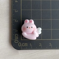 Pink resin rabbit with white wings charm accessory shown on a measurement cutting mat - 05 Solid Color Winged Pink Rabbit