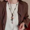 Detail view of ethnic wax rope necklace featuring wooden beads and metal pendants - Necklace #15 - Black - Brown