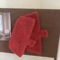 Cozy red knitted woolen gloves pinned on a corkboard as winter fashion accessory - Red
