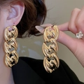 Primo piano di orecchini a catena dorati spessi indossati da una modella con finitura lucida - Orecchini - Oro (Con perno in argento 925)