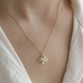 Detailed view of rotating windmill necklace with sparkling crystals on golden chain - Gold