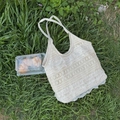 Gros plan détaillé du sac cabas en dentelle crème sur l'herbe pour un style pique-nique - Abricot