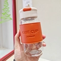 Dettaglio della bottiglia in vetro con custodia in pelle arancione e scritta ONE CUP - 550ml / Arancione