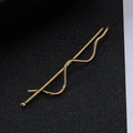 Close-up of golden wave hair clip with a smooth metallic finish on black background - Short Twist Clip