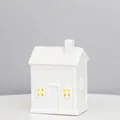 Detailed view of white ceramic house with cross-cut windows and warm LED glow, 12.5cm height - RH2280 (9x6.7x12.5cm)