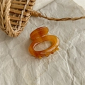 Close-up of amber acetate hair claw clip featuring the France Handmade engraving details - Striped Coffee