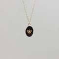 Detailed close-up of a gold stainless steel necklace with a black enamel butterfly pendant - Obsidian-Butterfly