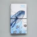 Carnet Marine Wizard avec illustration de baleine bleue et fermeture élastique noire - Sorcier Marin