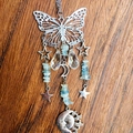 Detailed shot of silver butterfly suncatcher with blue crystals and moon pendant - Aquamarine