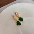 Retro gold titanium earrings with emerald green stone charms on a white ceramic plate - Emerald Green Stud Earrings