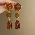Detailweergave van retro oorbellen met rozenreliëf, bruine kralen en amber hangers - 2# Zilveren oorbellenstift - Goud - Koffie