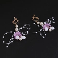 Detail of golden butterfly clip-on earrings with purple petals and white pearls - Clip-On Earrings / Purple