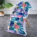 Detail of colorful tropical leaf print beach towel draped over a modern white chair - 70*150cm / Seagrass