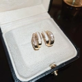 Close-up of golden floral heart earrings with white enamel and clear crystals in jewelry box - White Micro-Inlay (Real Gold Plated)