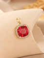 Macro shot of square gold pendant featuring red gemstone and clear cubic zirconia - Gold Magenta