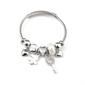 Detail of twisted silver bangle with heart charms, pearl and butterfly pendant decorations - White