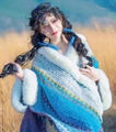 Close-up of blue knitted shawl with white faux fur trim and geometric patterns - White Blue