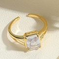 Close-up of golden adjustable ring with square clear gemstone on beige texture - Adjustable Open / Gold Rectangle