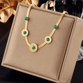 Close-up van een gouden slangenschakelketting met vijf turkooizen hangers in sieradendoos - Slangenketting met vijf turquoise stenen stijl (N1780)