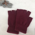 Detail view of burgundy knitted half-finger gloves with ribbed cuffs on white plush fabric - One Size / Burgundy