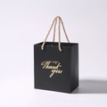 Detail of black thank you gift bag with gold foil lettering and woven handles - 13x8x15cm / Black + Champagne Handle