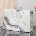 Elegant white marble gift bag with golden Happy Times text and silk ribbon bow - Jazz Flowing Gold