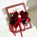 Detail of Christmas bow hair clip with Santa Claus charm and velvet ribbon texture - Bell & Glove Christmas Clip