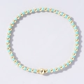 Elastic beaded bracelet featuring mixed gold beads and light blue accents in a chic style - Cyan and Gold