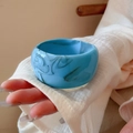Close-up of light blue acrylic bangle with grey marble texture worn on wrist - Sky Blue Smudge Texture Style / Light Blue