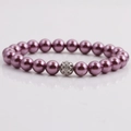 Detailed shot of dark purple pearl bracelet with a silver hollow rhinestone charm ball - Deep purple