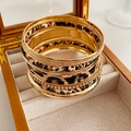 Détail de joncs imprimé léopard et anneaux en strass dans une boîte à bijoux en bois - Ensemble Imprimé Léopard Or et Café