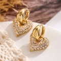 Elegant gold heart earrings with white zircon stones on a white stone background - Style 43890