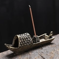 Vintage bronze boat incense burner with sparrow detail on rustic wood surface - Origami Boat