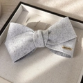 Dettaglio fiocco in velluto grigio con targhetta dorata handmade su tessuto morbido - Bianco Sporco