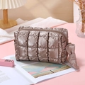 Portable brown quilted makeup bag with metallic finish and bow zipper in a warm setting - Octagonal Pouch / Brown