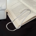 Artistic detail of silver flat snake chain necklace resting on a book and fabric - Silver Single Layer Snake Bone Necklace