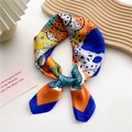 Elegante zijden sjaal met bloemenprint in oranje en blauw geknoopt als een strik - Bladhart met blauwe rand