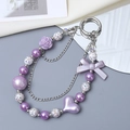 Detail of purple acrylic heart and bow keychain with silver chains and faux pearls - Charm / Purple