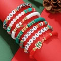 Close-up of Christmas heishi bead bracelets with Joy letters and festive charms - SY0968-1/Pine Cone Background Scene Style