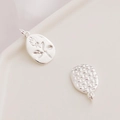 Detail of silver rose embossed pendant and woven textured charm on ceramic tray - Silver Flower Bud