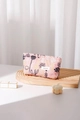 Gros plan détaillé de la broderie florale et de l'étiquette sur une trousse rose - Petit / Rose