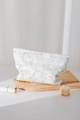 Vue détaillée d'une trousse à maquillage en coton avec motifs floraux bleus et étiquette - Fleur Bleue Élégante