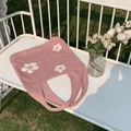 Detail der Strickstruktur einer rosa Häkeltasche mit weißen Blumenmustern im Freien - Kirschblütenrosa