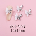 Macro detail of white resin butterfly nail charms with rhinestones on a nude nail tip - White Shell Texture Patchwork Rhinestone Style (AF87)