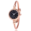 Macro view of rose gold twisted bangle watch featuring a minimalist black round dial - Rose Gold Black Dial Linear Scales