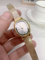 Detail of Gogoey gold oval watch with mesh band held against a lifestyle background - Gold Steel Strap White Dial