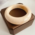 Detailed top view of wide marbled resin bangle in cream white with amber texture - Beige