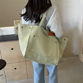 Quilted light green tote bag with large front pocket and brown leather label accent - Quilted Grid / Green